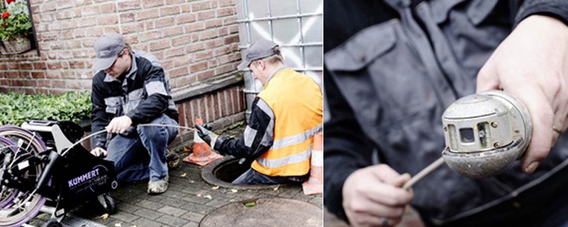 Zwei Männer arbeiten an einem Abfluss und einer hält eine Kamera