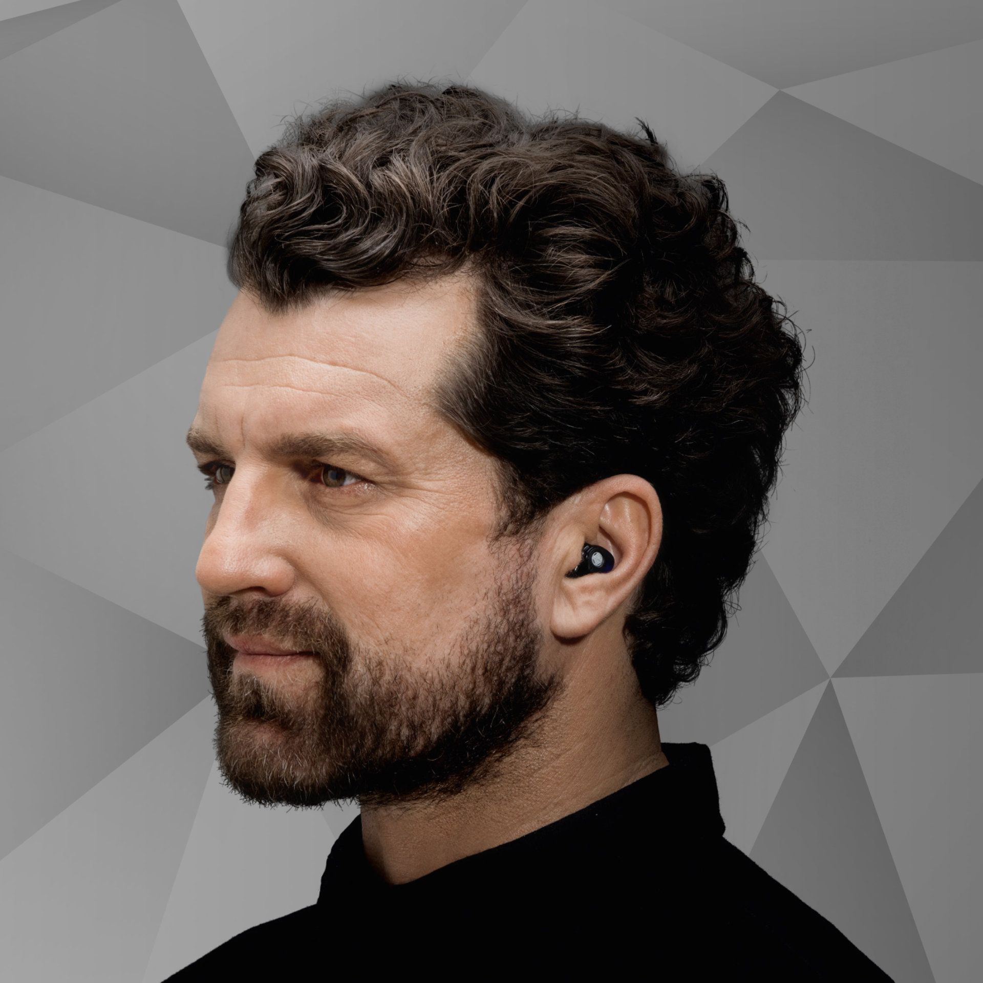 Ein Mädchen mit einem Hörgerät. Das Mädchen nimmt ein Hörgerät an. Im Raum. Glückliches Mädchen, das wieder gut hört