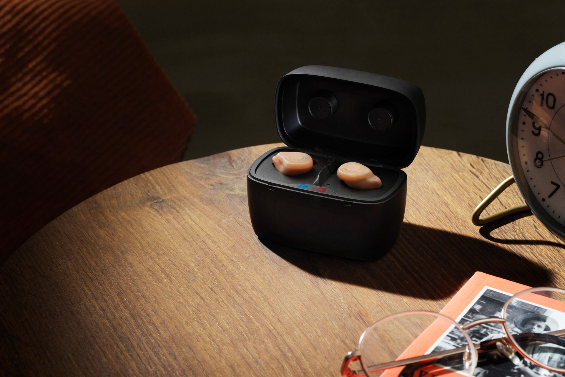 Der Arzt gibt einem Kind mit Hörverlust ein Hörgerät. Freundlicher Audiologe hält ein modernes kleines Hörgerät in der Hand und gibt es einem gehörlosen, hörgeschädigten Schuljungen. Audiologiekonzept