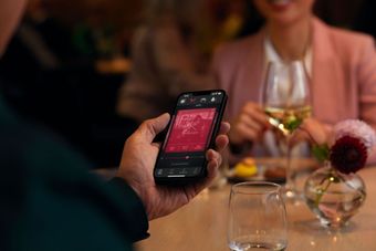 Eine Person mit einem Handy auf dem eine App für die Hörgeräte abgebildet ist Eine Person mit einem Handy auf dem eine App für die Hörgeräte abgebildet ist