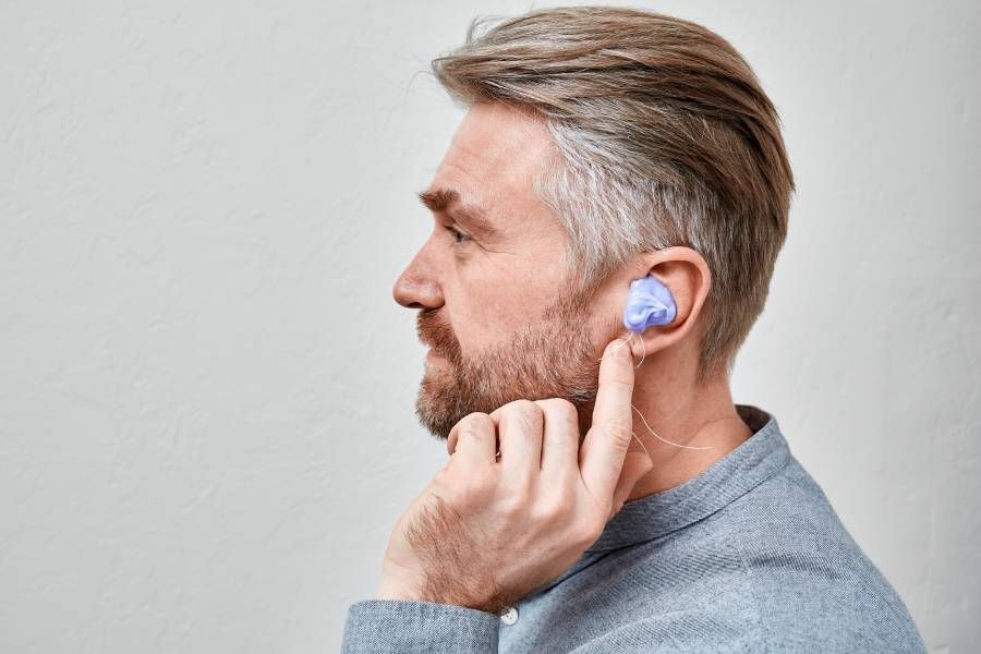 Herstellung individueller In-Ear-Formen. Mann mit Silikonmaterial im Ohr während der Herstellung einer individuellen Otoplastik für sein Hörgerät in der Audiologie-Klinik