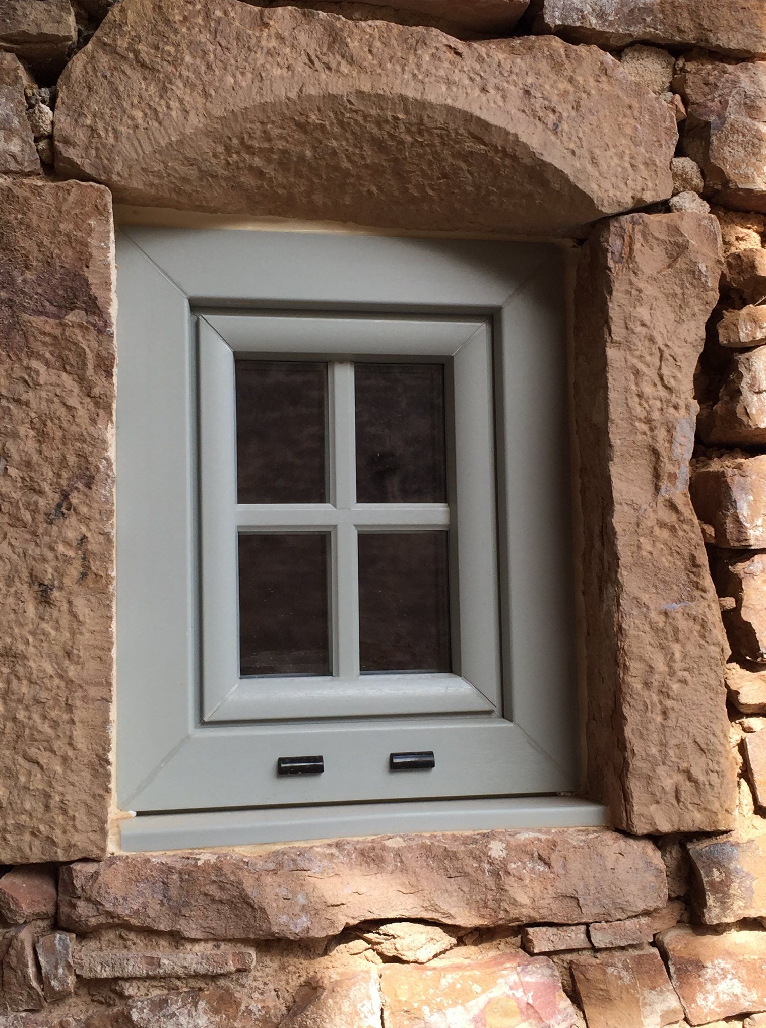 Photo d'une fenetre opaque avec encadrement en pierre