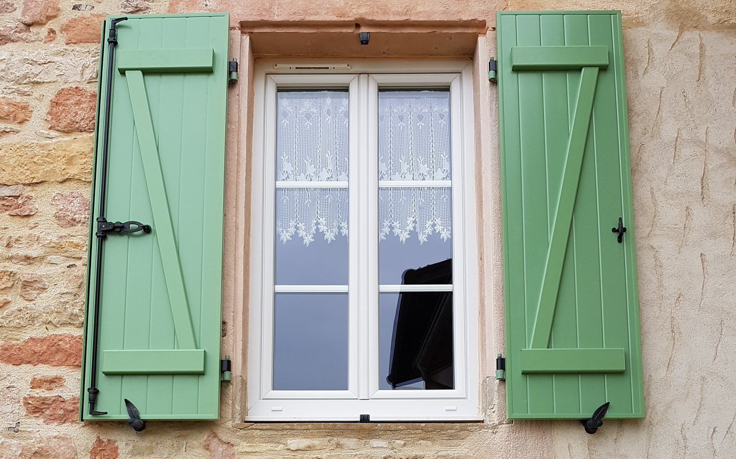 Photo de volets batants vert et fenêtre PVC