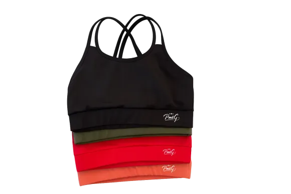 Pila de sujetadores deportivos atléticos en negro, verde, rojo y naranja, con tirantes cruzados.