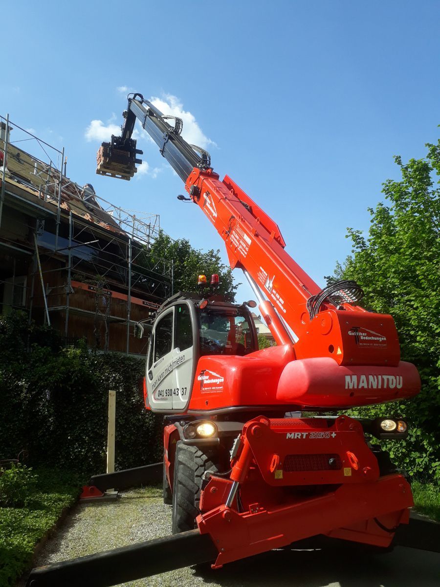 ein roter Manitou-Truck steht vor einer Baustelle