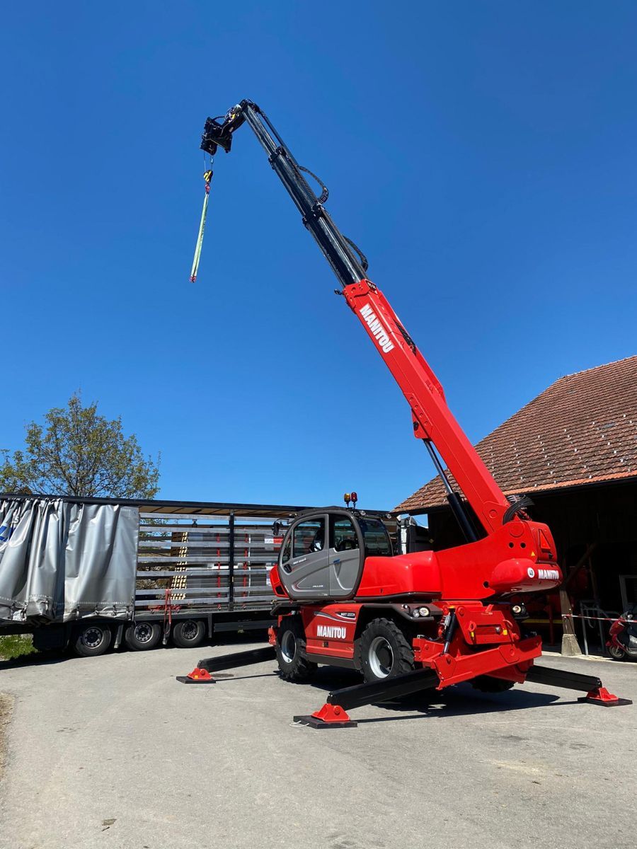 ein roter Manitou-Truck steht vor einer Baustelle