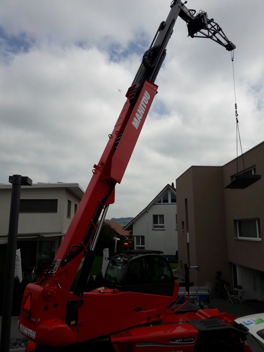 ein roter Manitou-Truck steht vor einer Baustelle