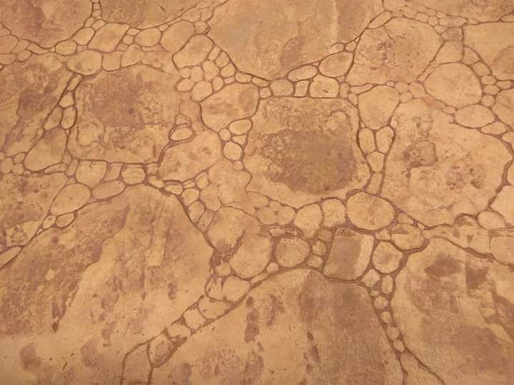 Primer plano de una superficie de piedra agrietada de color marrón claro o de barro seco con patrones
