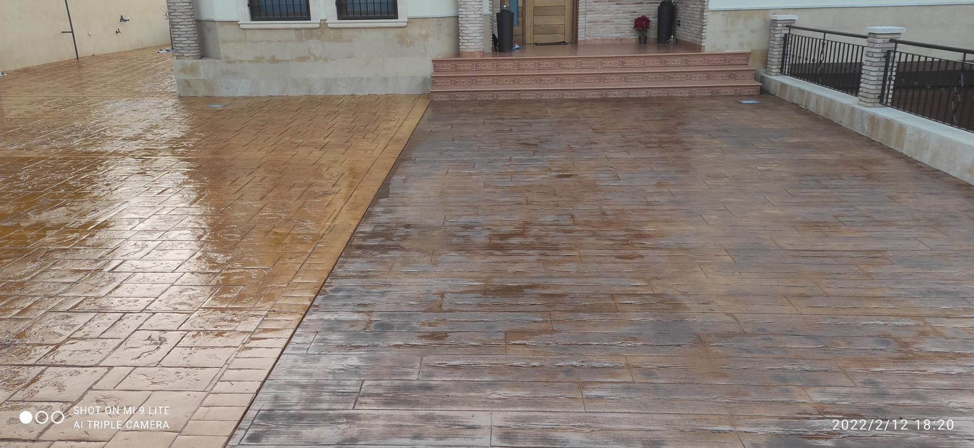 Rampa de madera y baldosas mojada que conduce a la entrada de un edificio después de la lluvia.
