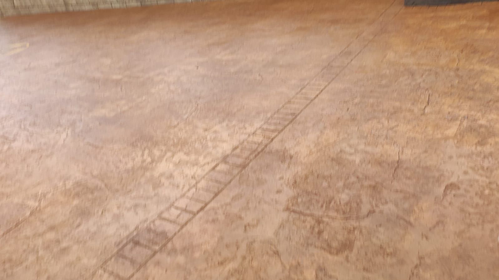 Suelo de hormigón color beige vacío con una línea de unión diagonal.