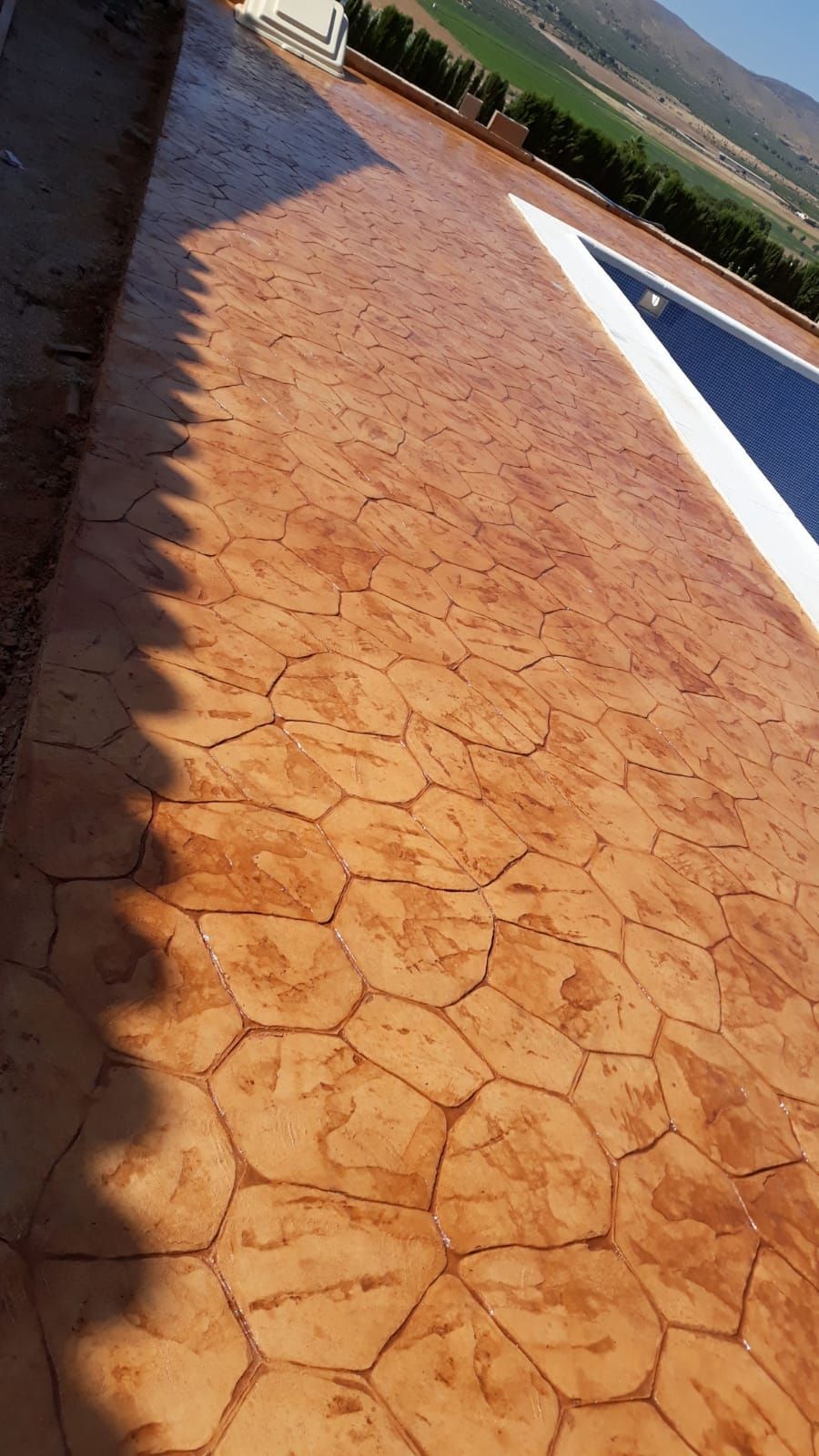 Tejado de color naranja tostado agrietado junto a un panel solar bajo un cielo despejado.