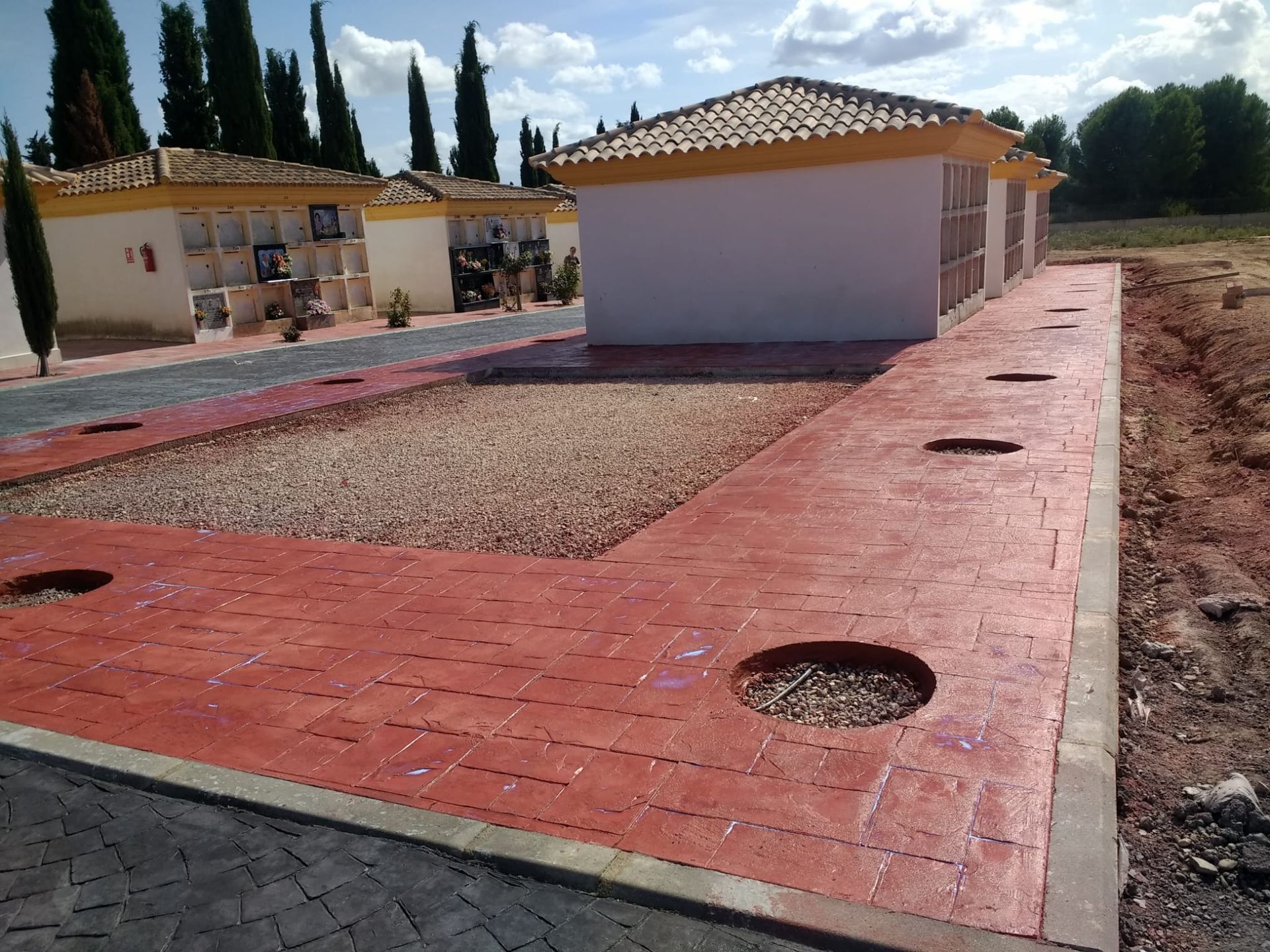 Casas de una sola planta con patios de baldosas rojas y jardines de grava en una zona residencial rural.