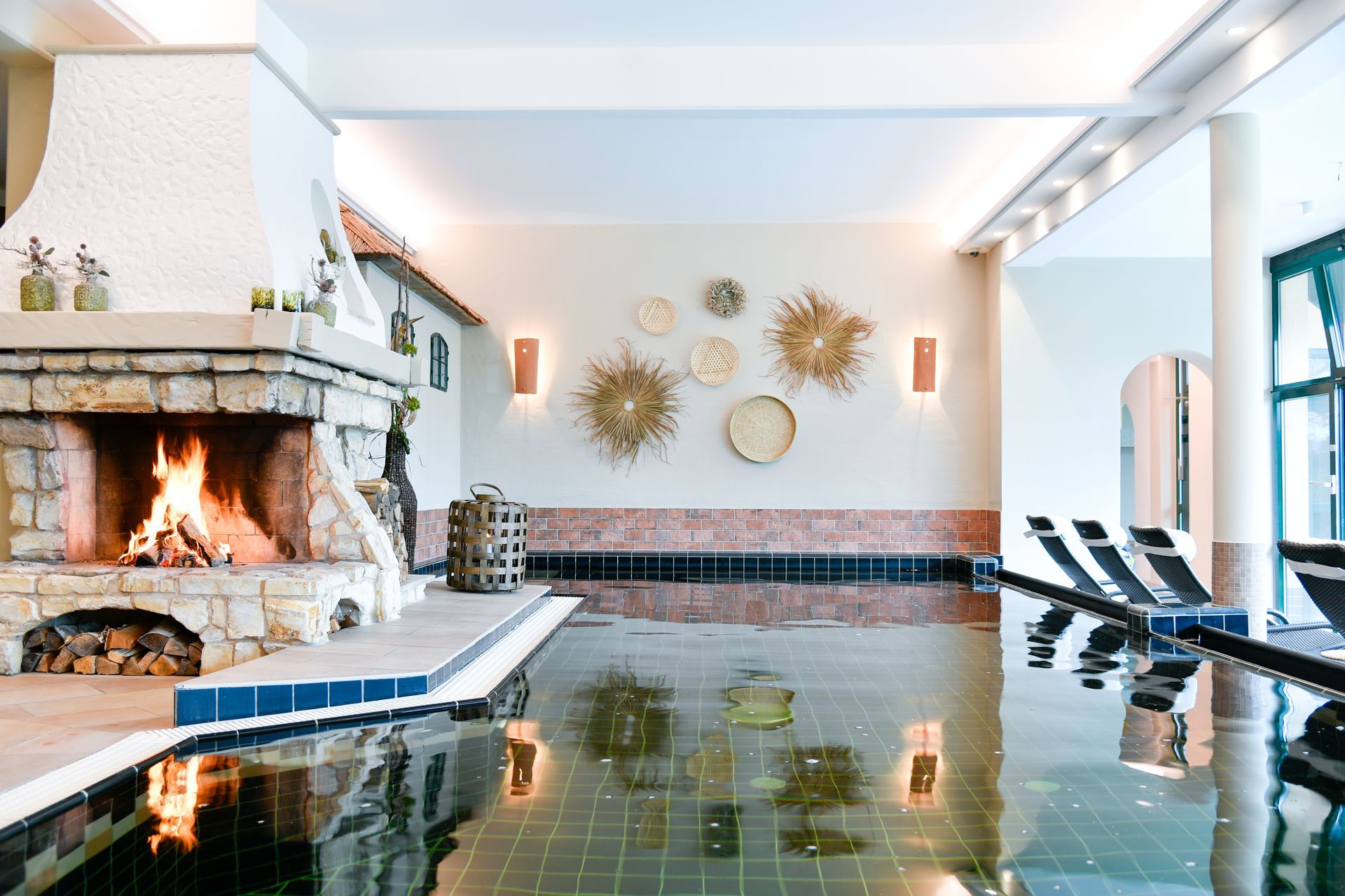 Innenpool mit Kamin und dekorativen Wandbehängen.
