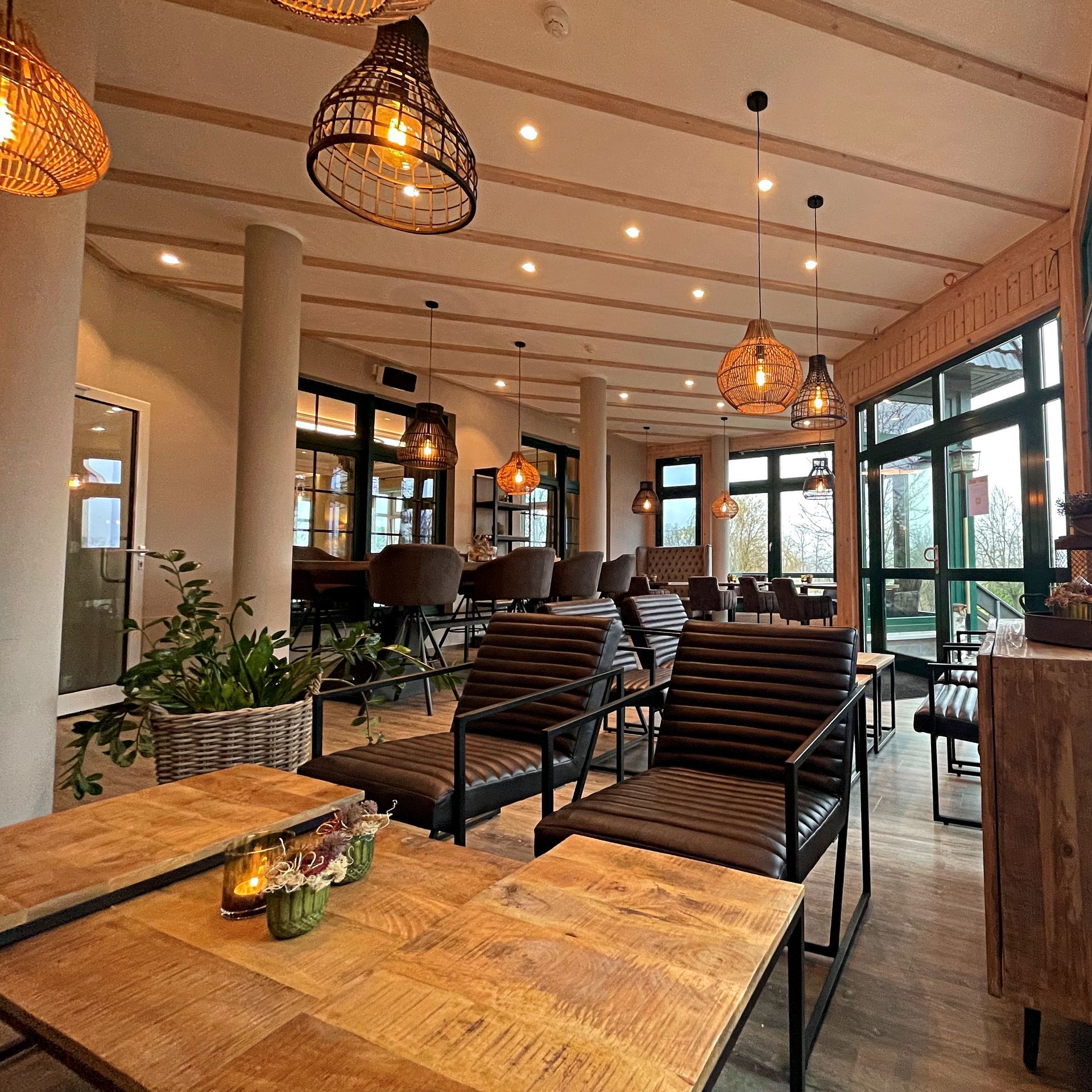 Offene Restaurant-Lounge mit großen Fenstern und stilvoller Einrichtung