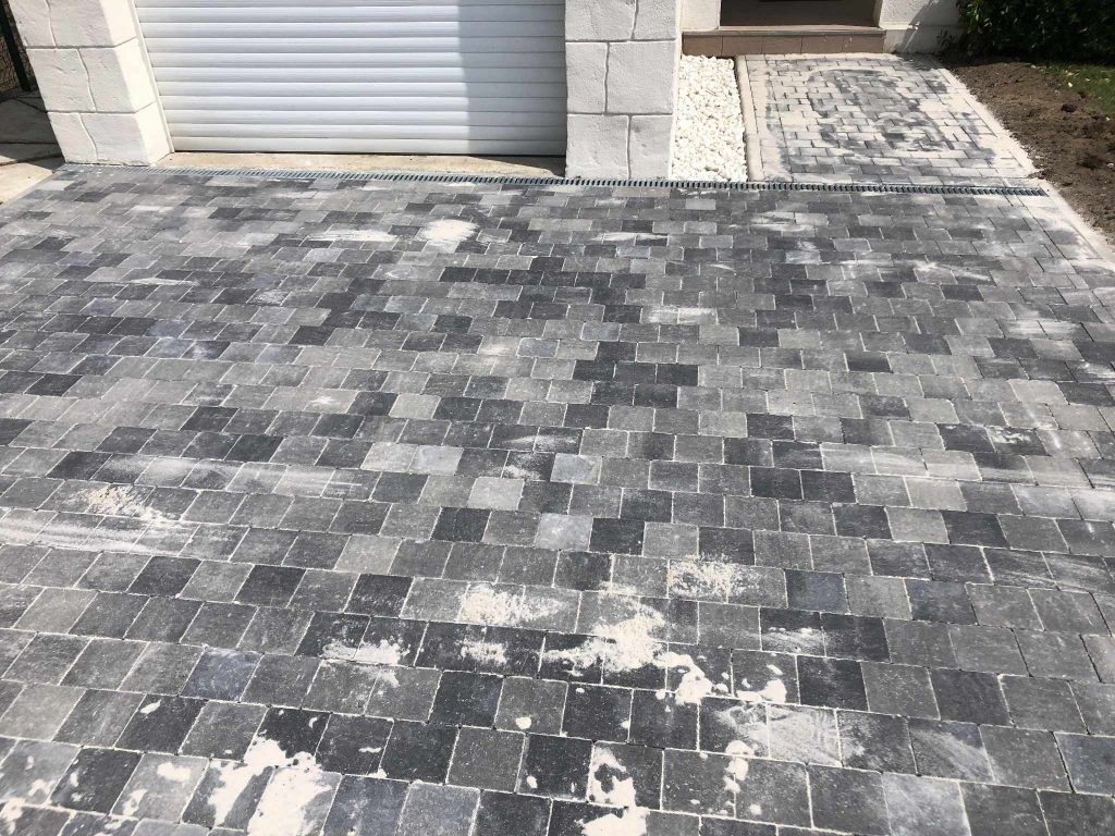 Pavés sombres devant un garage