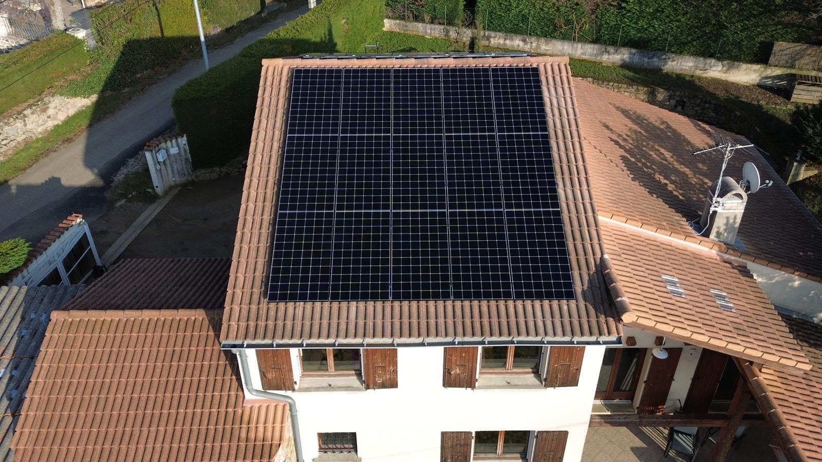 Maison sur plusieurs niveaux avec panneaux photovoltaïques sur son toit le plus haut.