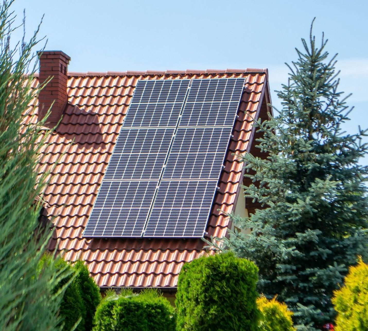 Panneaux photovoltaïques sur une toiture en tuiles un jour de beau temps.