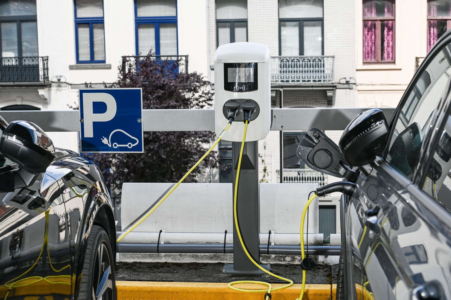 Borne de recharge électrique blanche sur un parking.