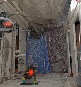 Un hombre con guantes amarillos está trabajando en un edificio.