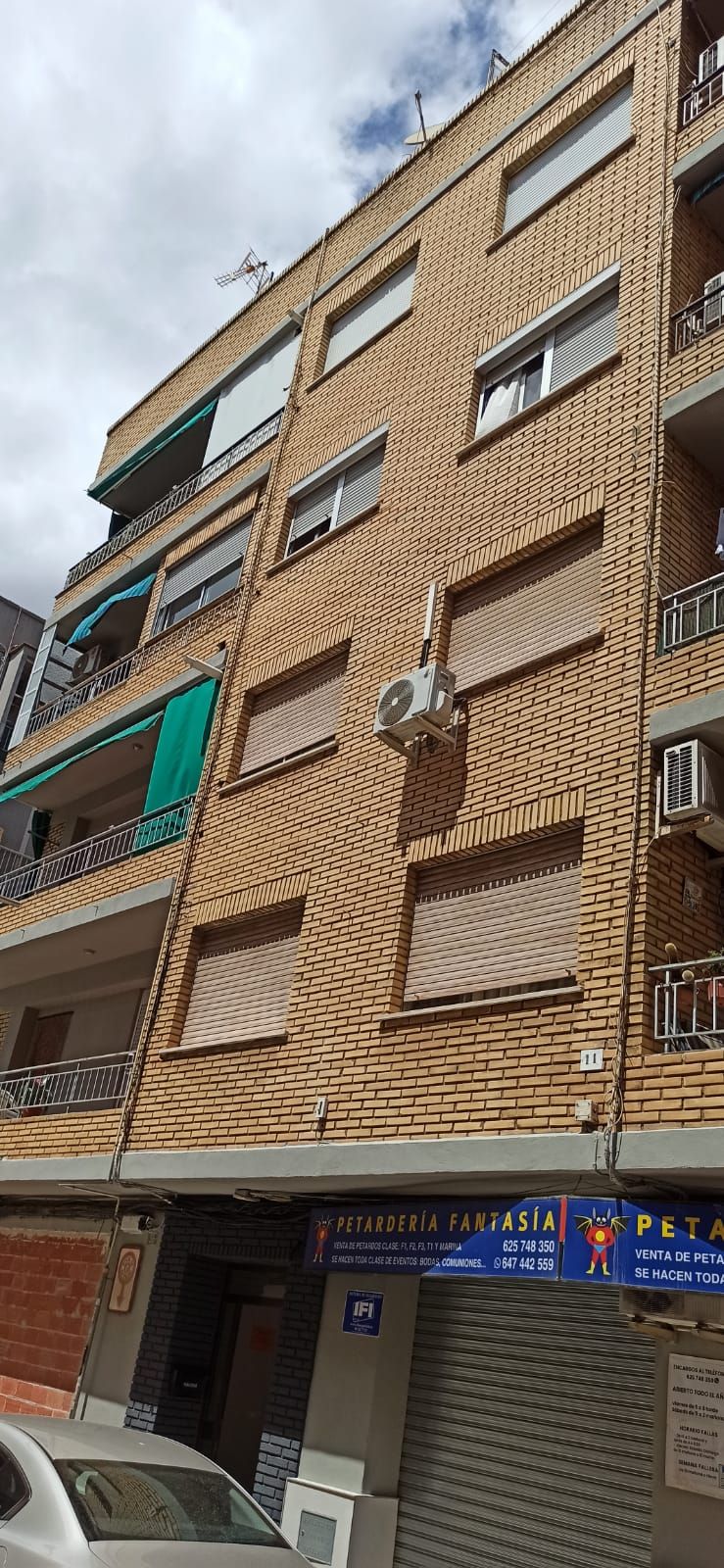 Dos hombres están pintando el costado de un edificio azul.