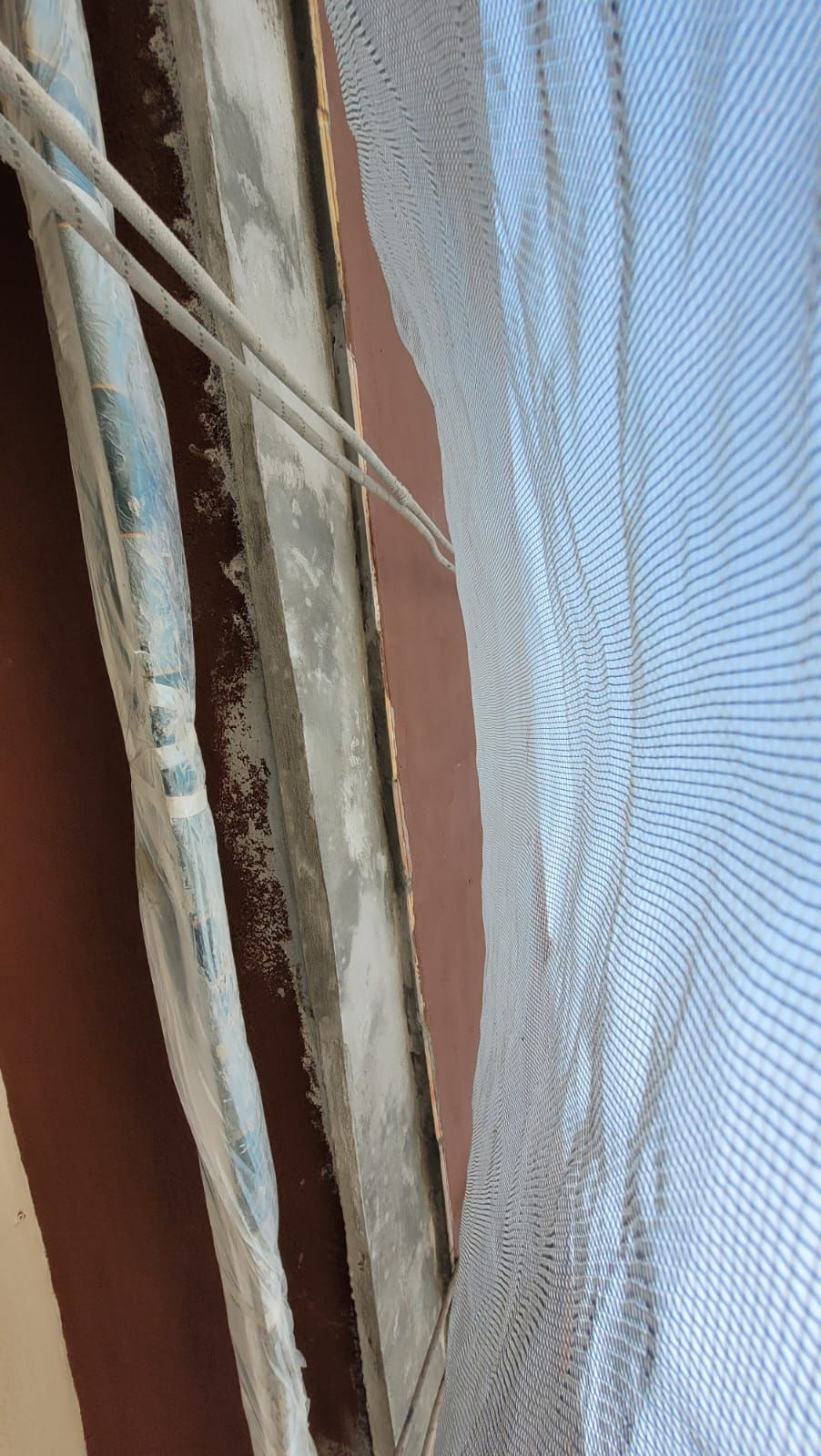 Una persona está cortando un agujero en una pared con un par de tijeras.