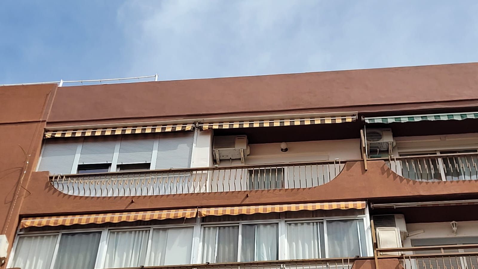 Un edificio marrón con muchas ventanas y balcones.