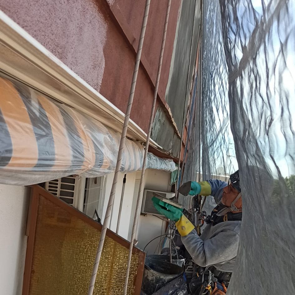Un hombre con guantes amarillos está trabajando en un edificio.