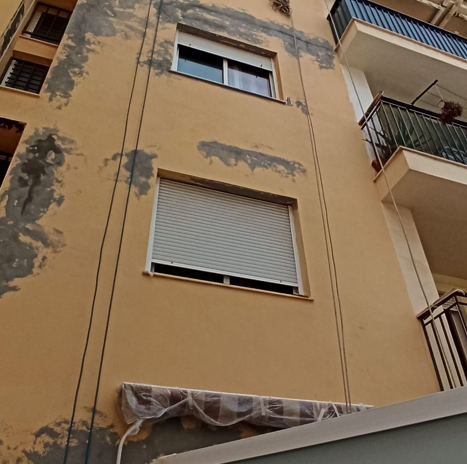 Un edificio con muchas ventanas y un balcón.