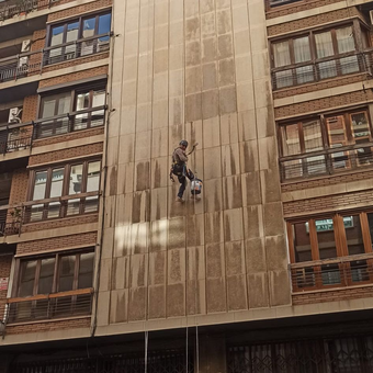 Un hombre está subiendo por el costado de un edificio.