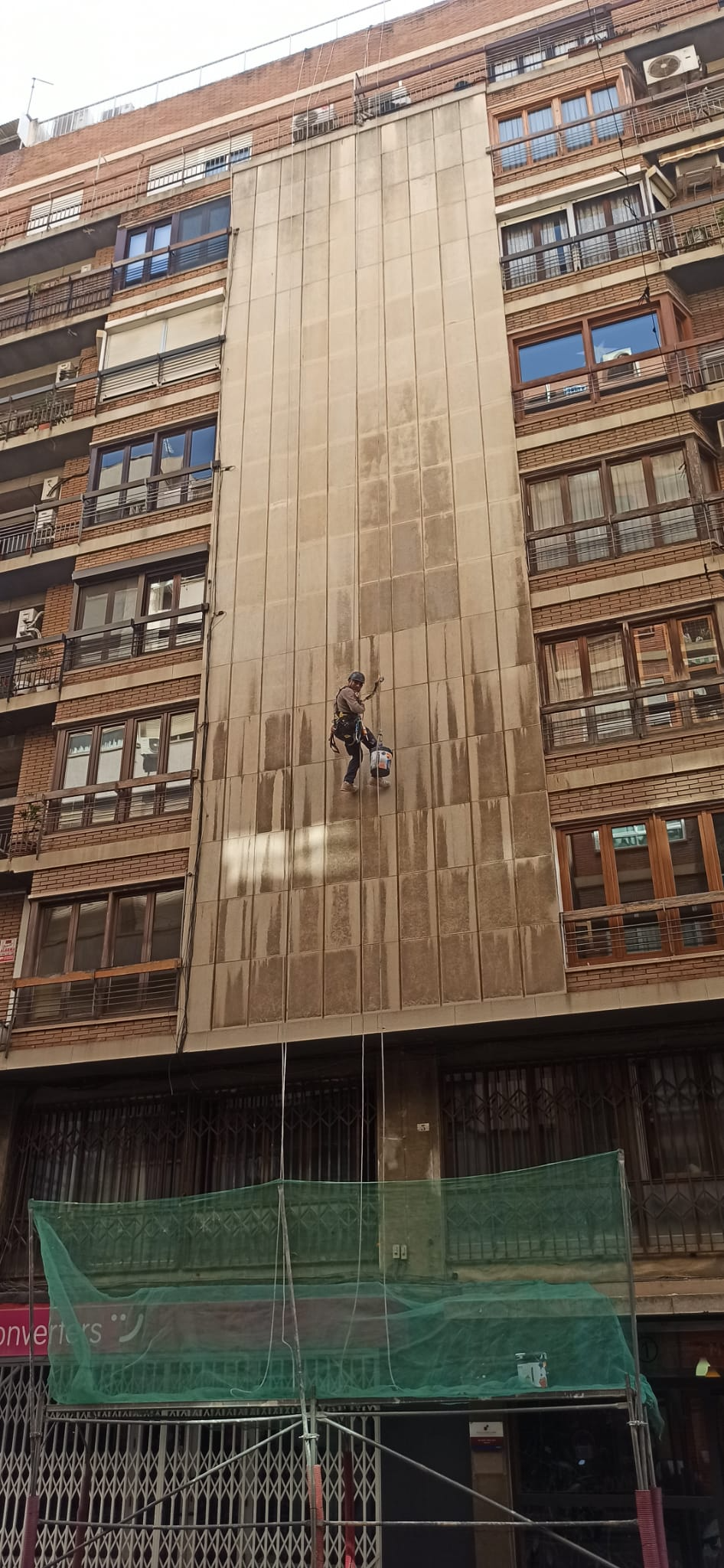 Un hombre está subiendo por el costado de un edificio.