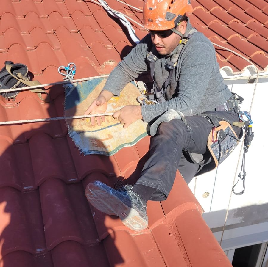 Un hombre que lleva un casco está sentado en un tejado.