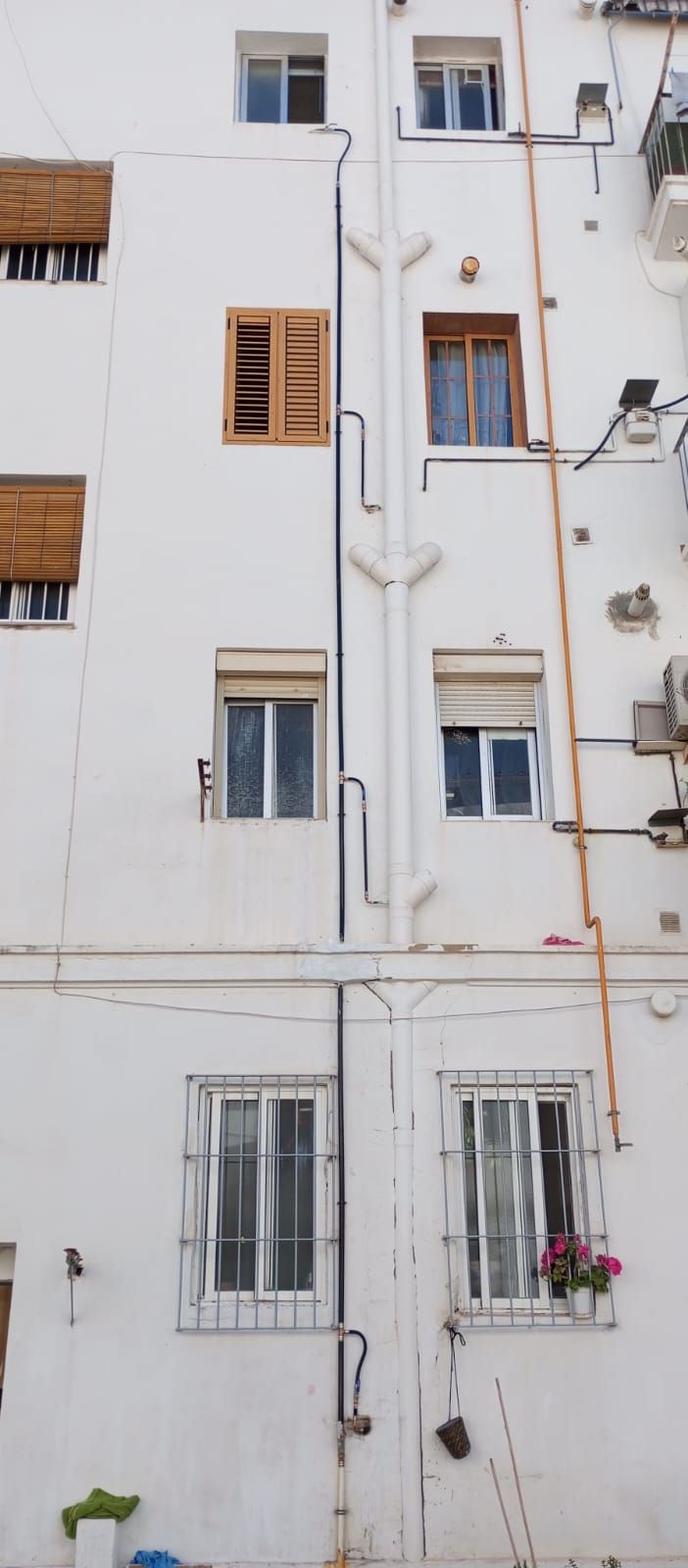 Un edificio blanco con muchas ventanas y contraventanas.