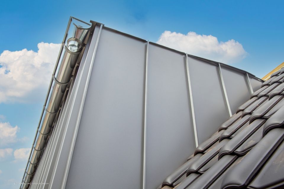 Eine Gruppe Männer arbeitet auf dem Dach eines Gebäudes.