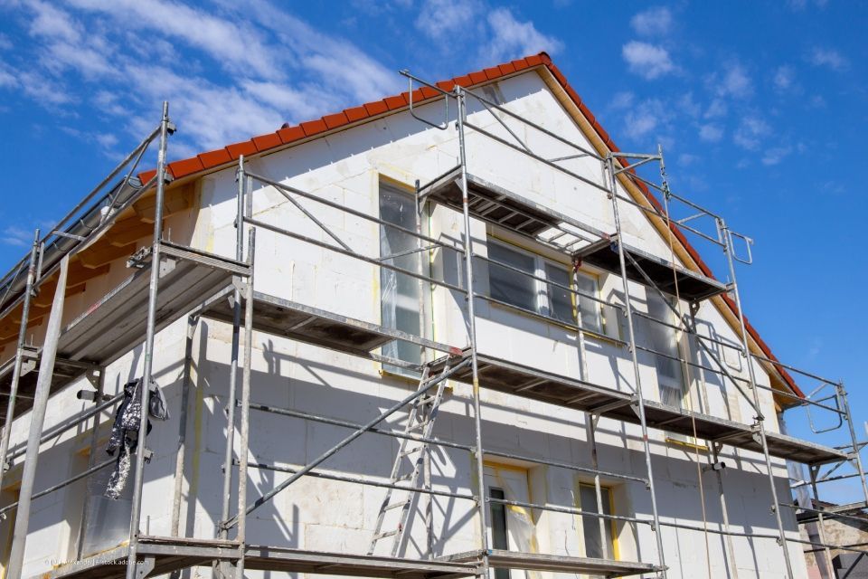 Eine Gruppe Männer arbeitet auf dem Dach eines Gebäudes.