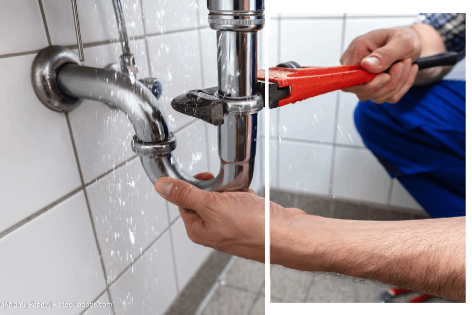 Klempner repariert ein undichtes Abflussrohr mit einem Schraubenschlüssel, Wasser sprüht.