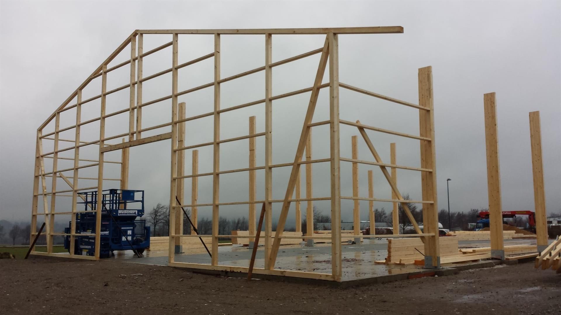 An einem bewölkten Tag wird eine große Holzkonstruktion errichtet