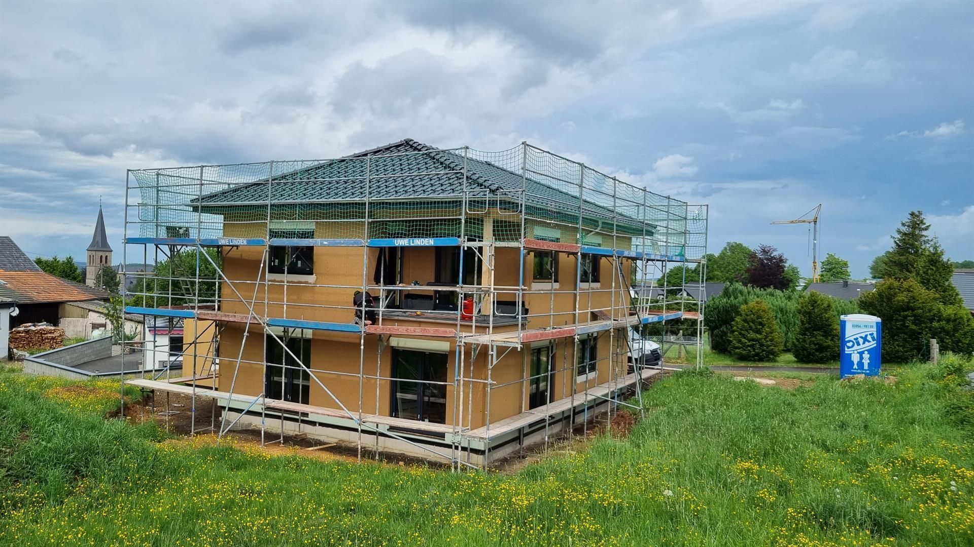 Ein Haus, das mit einem Gerüst darum herum gebaut wird