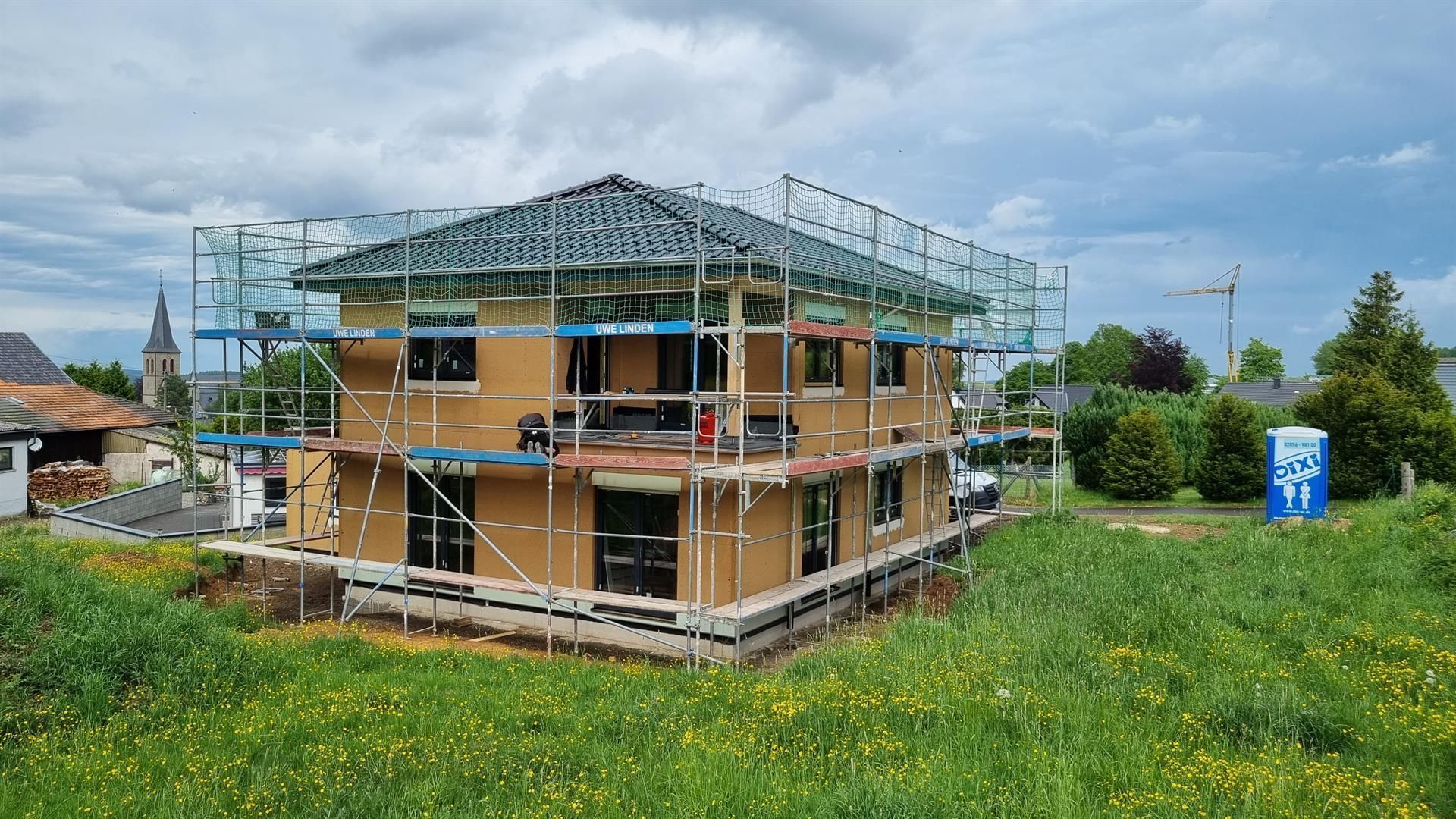 Ein Haus, das mit einem Gerüst darum herum gebaut wird