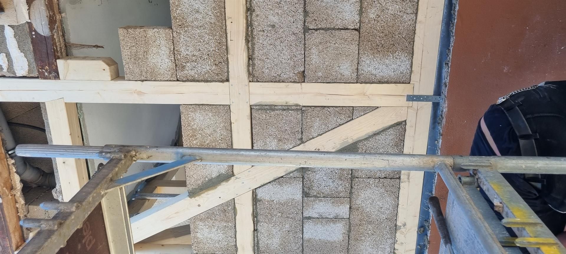 Eine Ziegelwand wird mit einem Holzrahmen gebaut