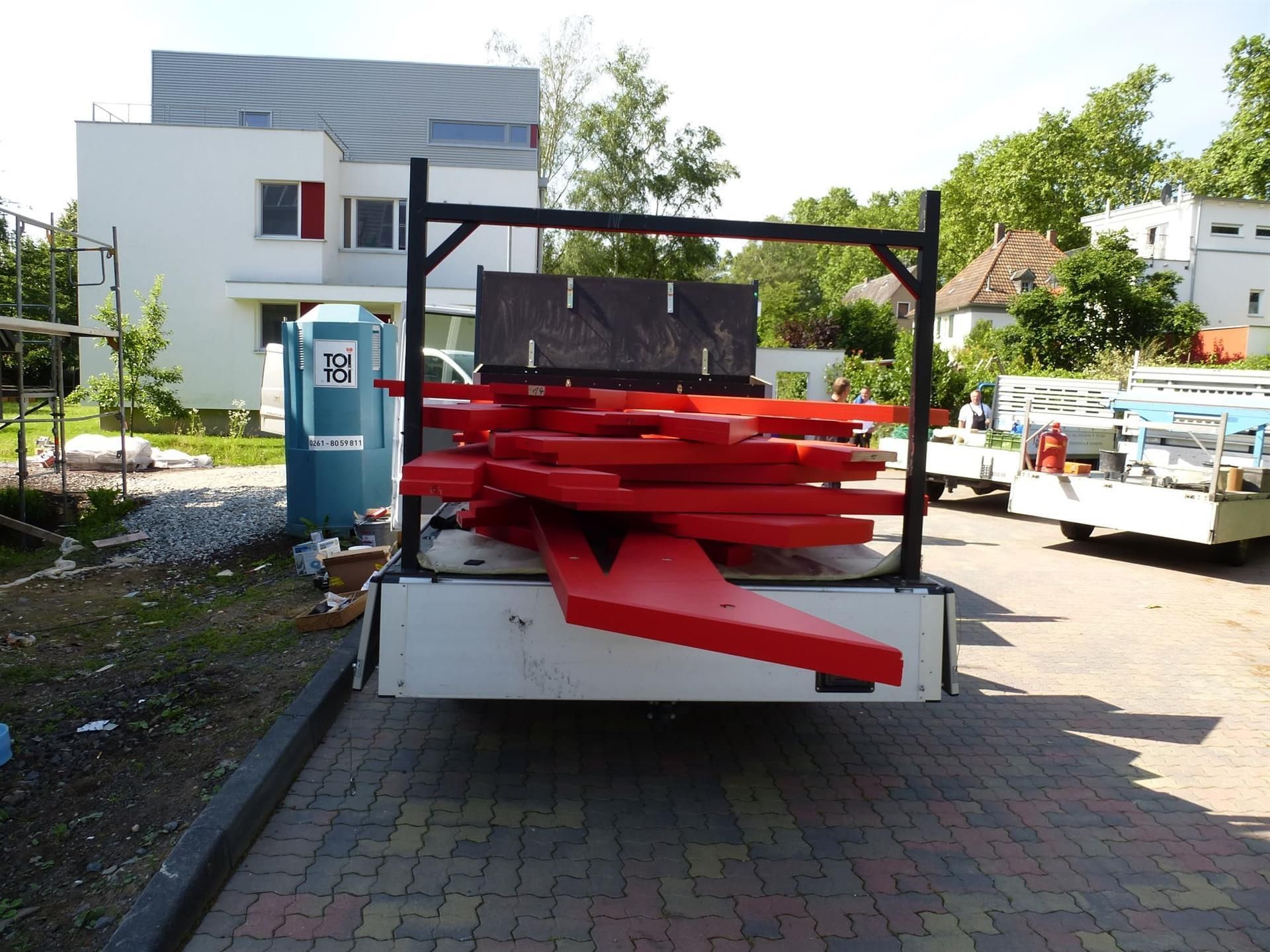 Ein weißer Lastwagen mit einem Stapel roter Spielsteine ​​auf der Ladefläche