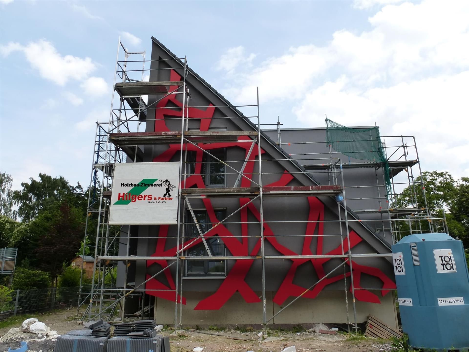 Ein im Bau befindliches Gebäude mit Gerüsten und einem Schild mit der Aufschrift 