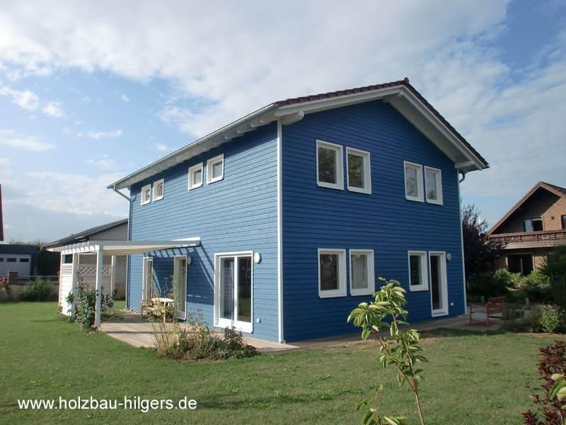 Ein blaues Haus mit der Website www.holzbau-hilgers.de in der Ecke