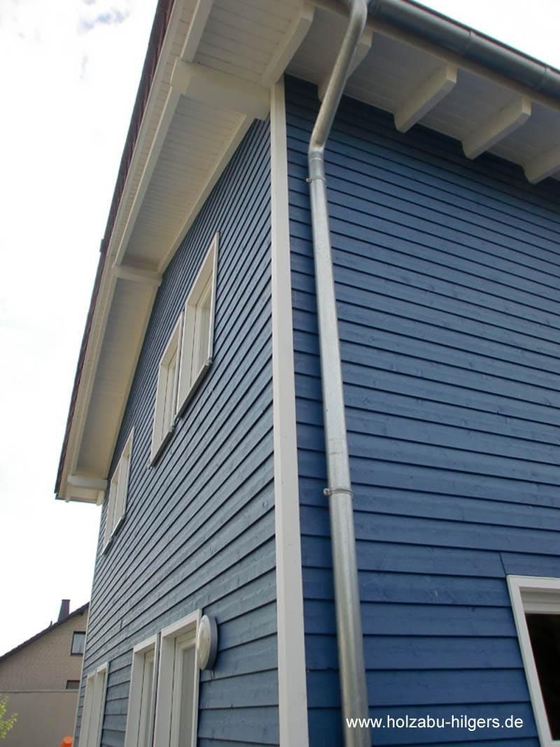 Ein blaues Haus hat eine weiße Dachrinne an der Seite