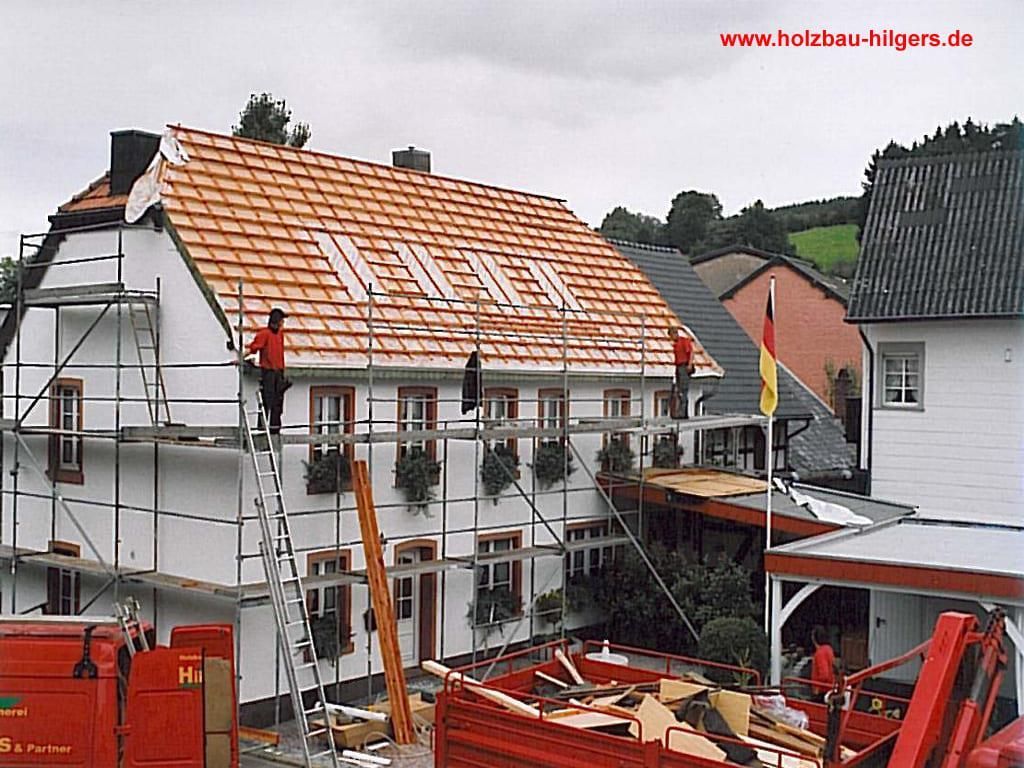 Ein Bild eines im Bau befindlichen Hauses mit der Website www.holzbau-nilgers.de am unteren Rand