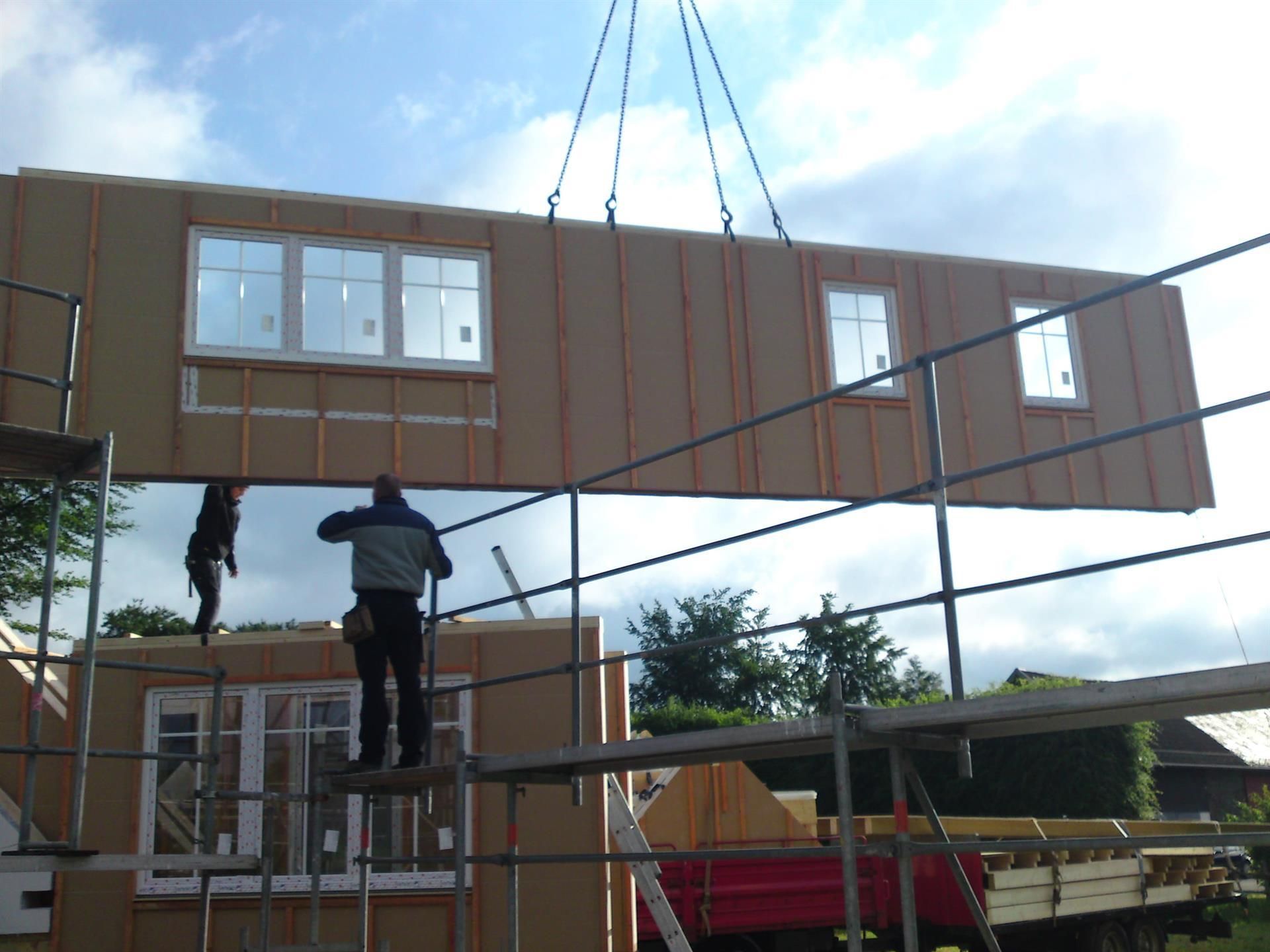 Ein Mann steht auf einem Gerüst vor einem im Bau befindlichen Gebäude