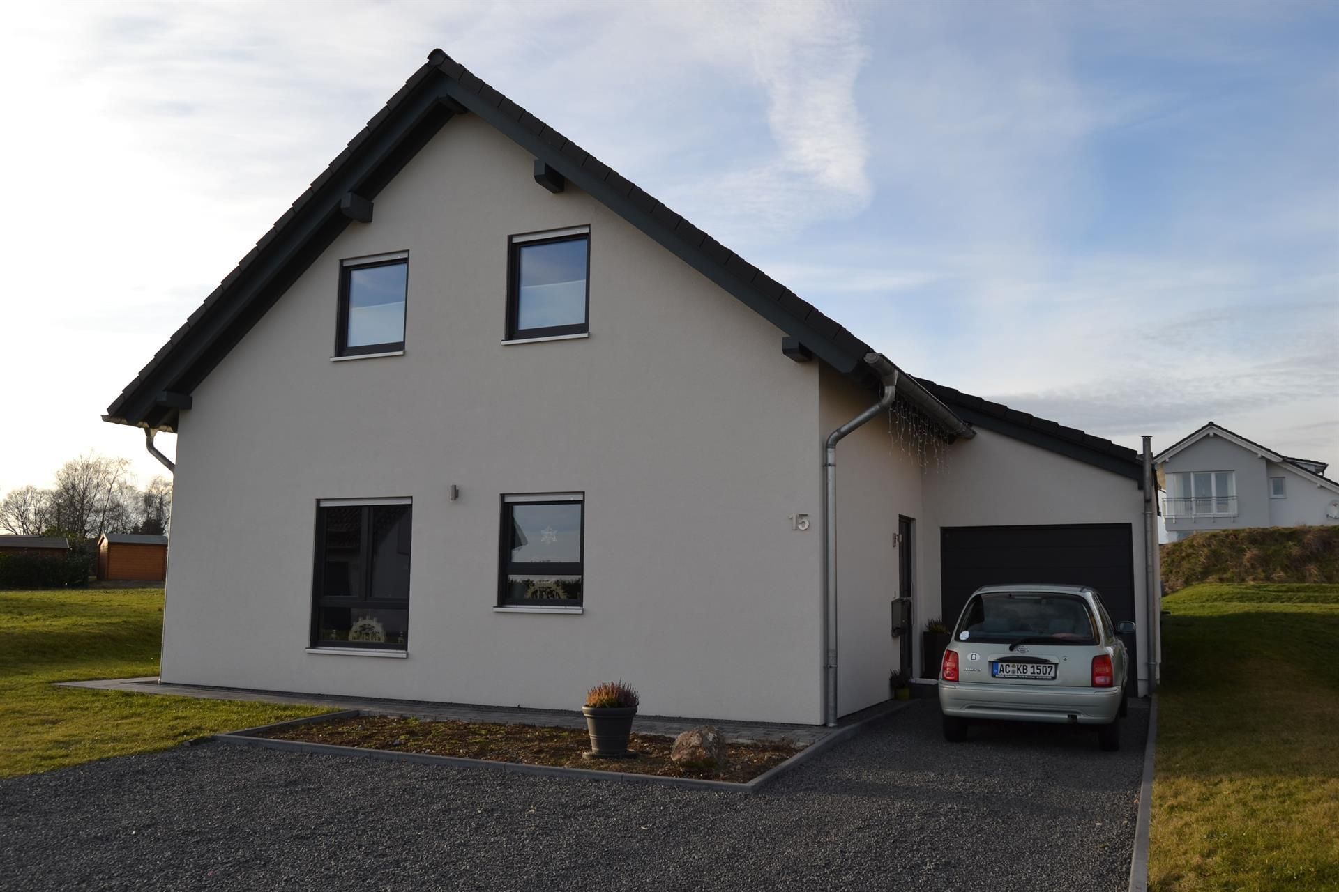 Ein weißes Auto steht vor einem weißen Haus