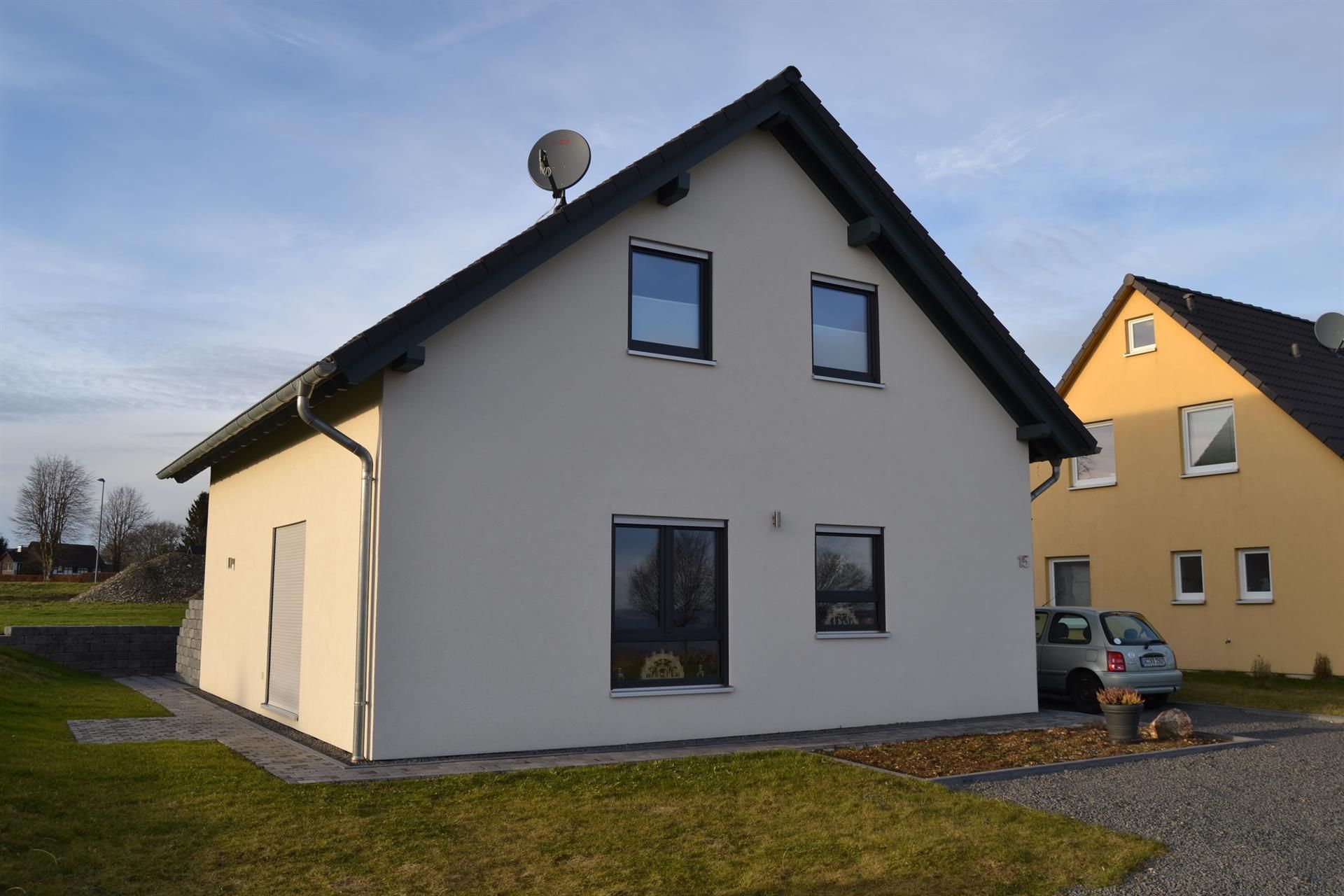 Ein weißes Haus mit einem davor geparkten Auto