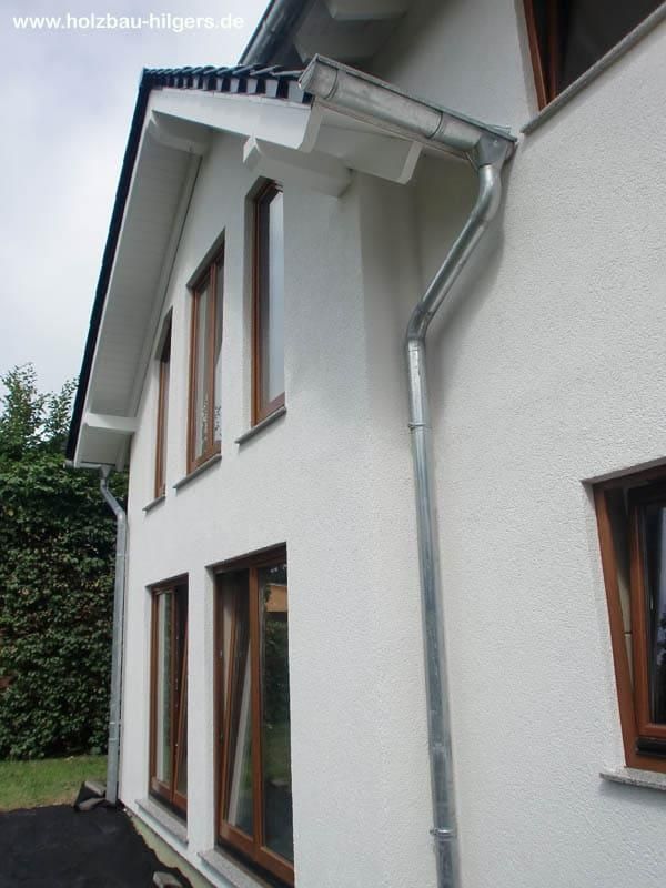 Ein weißes Haus mit einer Dachrinne an der Seite