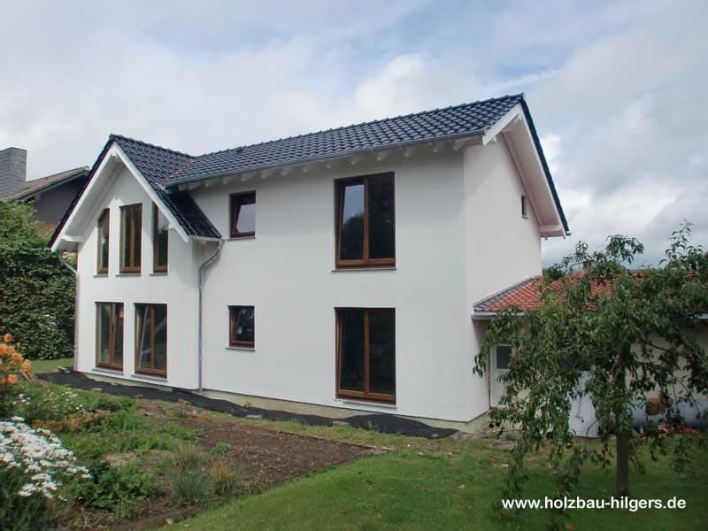 Ein weißes Haus mit schwarzem Dach und schwarzen Fenstern