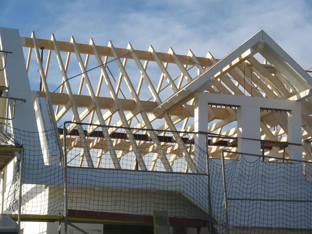 Das Dach eines Hauses wird mit Holzbalken gebaut